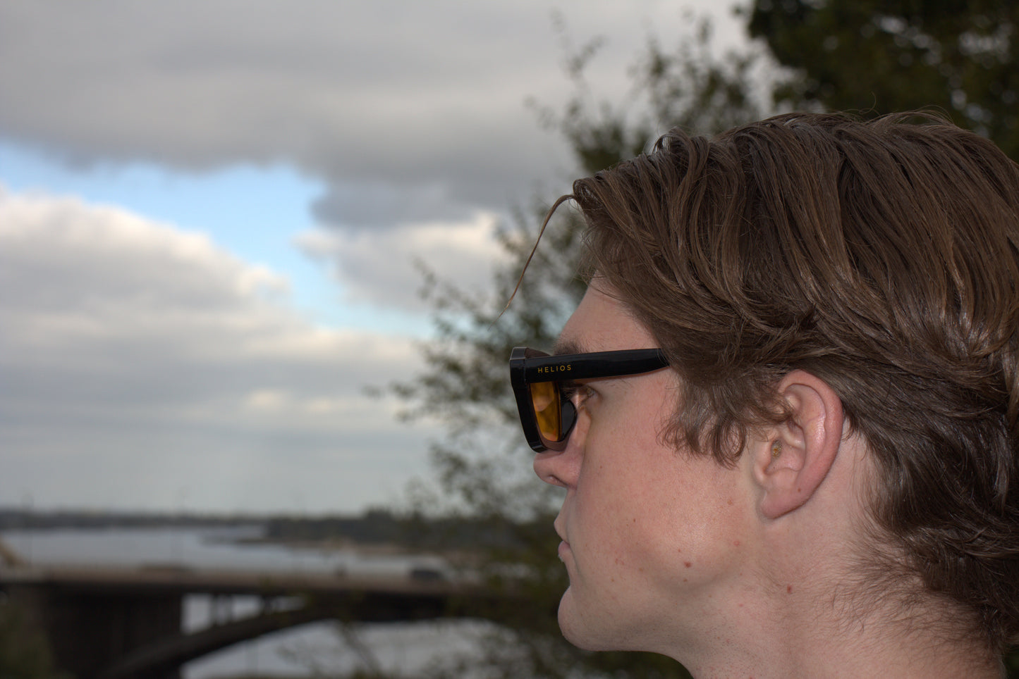 Person wearing sunglasses with a blurred natural background